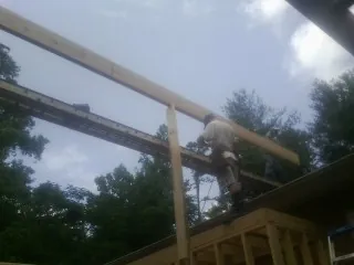 Carpenter setting a ridge beam over a new addition frame — Ice Dam Removal by Roofing Brothers in West Harwich