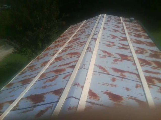 Rusted metal roof panels with new wood purlins before replacement — Storm Damage Roof Repair in West Harwich by Roofing Brothers