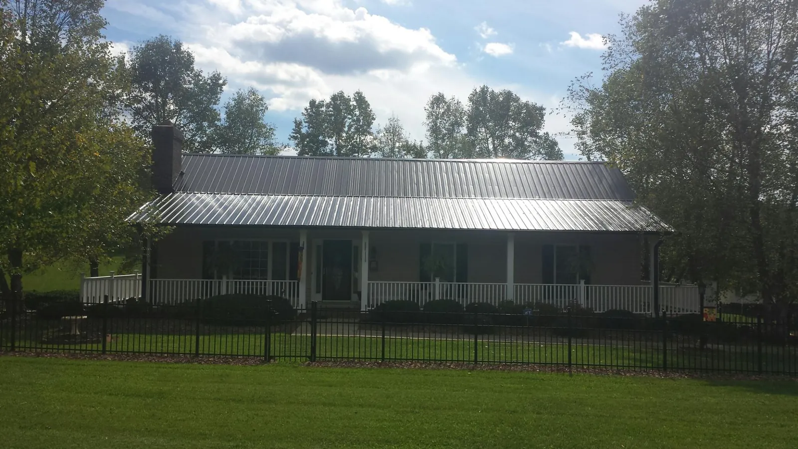 Gray metal roof on a brick ranch with a full width front porch — Gutter Guard Installation work by our crew in West Harwich