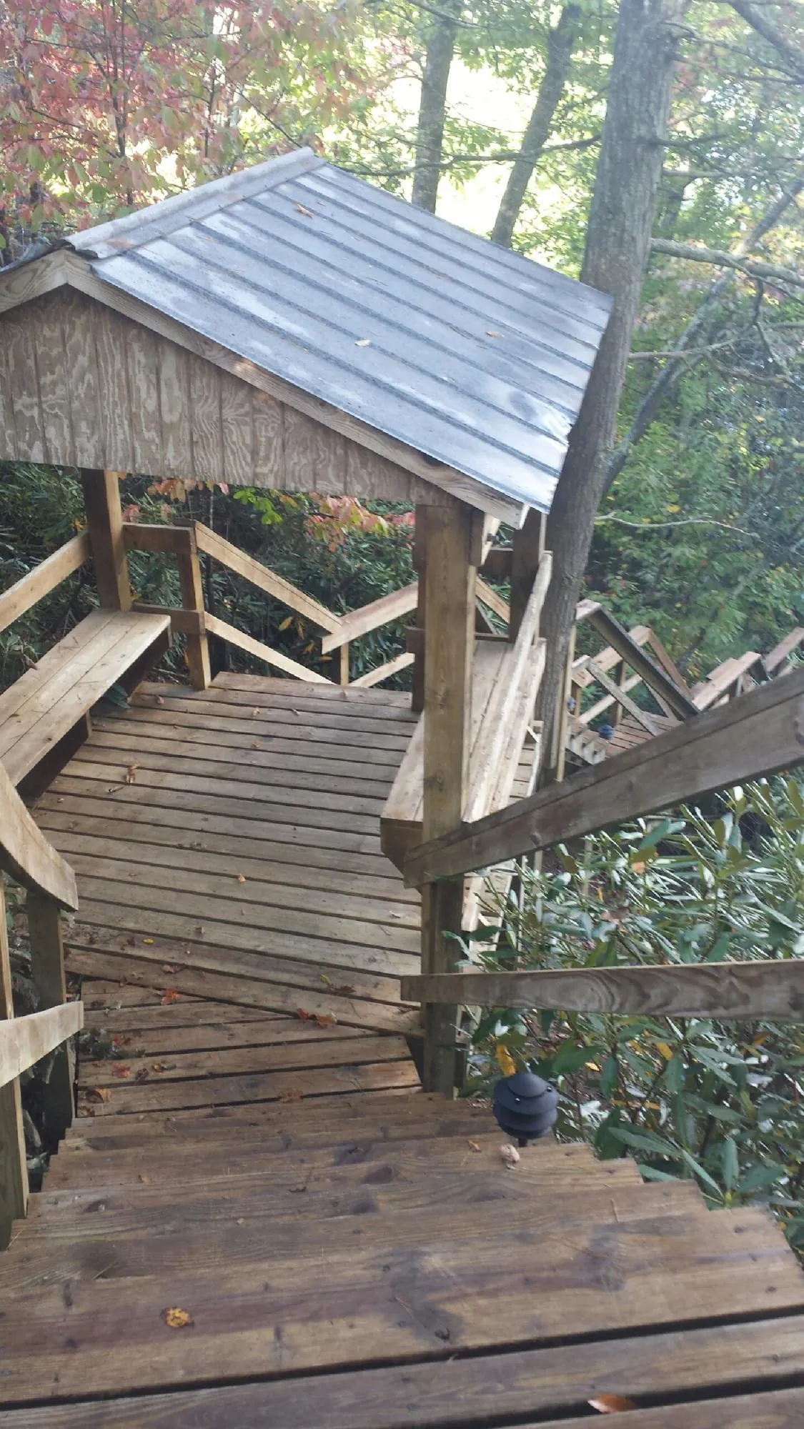 Metal roofed shelter over wooden steps on a wooded walkway — Skylight Repair & Installation work by our crew in West Harwich